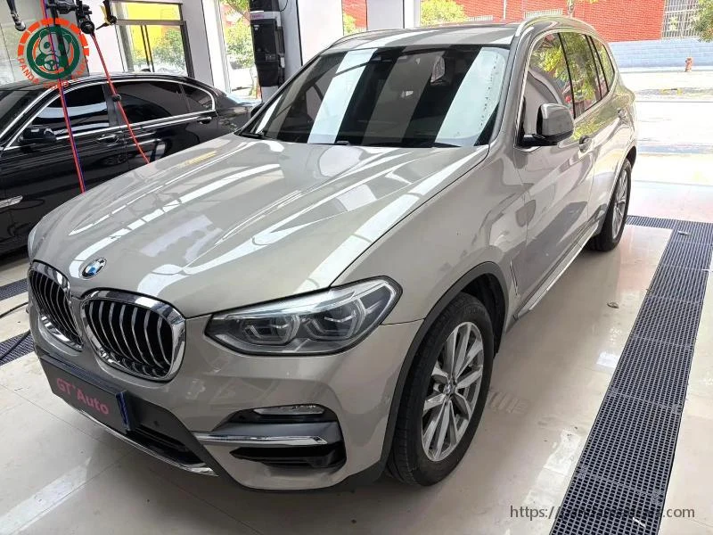 Silver BMW X3, front three-quarter view inside a workshop